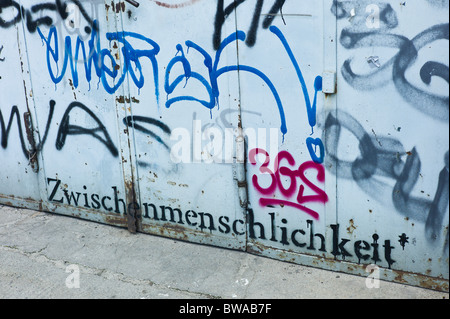 Porte en acier gris recouvert de punaises et le mot 'zwischenmenschlichkeit', arena treptow, Berlin, Allemagne Banque D'Images