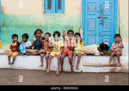 Les garçons et les filles du village indien est assis à l'extérieur d'une chambre avec une chèvre dans l'ancien village de Puttaparthi, Andhra Pradesh, Inde Banque D'Images