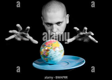 Image conceptuelle du modèle de la terre sur une soucoupe avec le magicien en gardant ses mains sur elle Banque D'Images