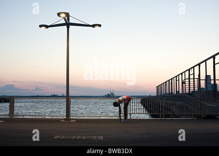 Runner stretching par river Banque D'Images