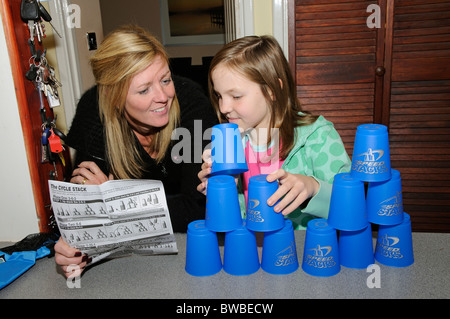 Jeune fille jouant avec des piles de vitesse de lecture de la notice d'instruction de la mère Banque D'Images