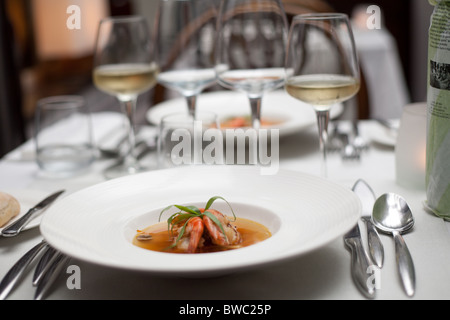 Plat de crevettes géantes grillées et le bouillon dans un wok de légumes, servi sur une table dans un restaurant. Banque D'Images