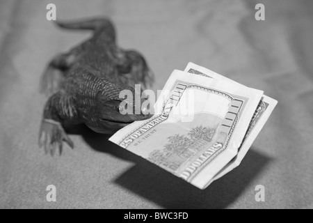 Lézard dragon de Komodo en bois sculpture souvenir nous mordre 100 Monnaie dollar bank note dans sa bouche Banque D'Images