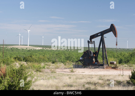 Pumpjack dans un champ de pétrole, à côté d'une ferme éolienne de haute technologie des turbines d'énergie éolienne dans la région de Texas Panhandle Banque D'Images