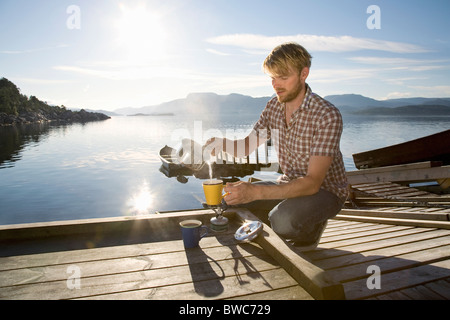 Faire le café de l'homme sur la mer par la jetée Banque D'Images