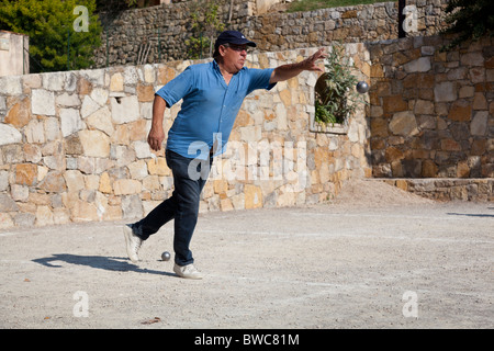 Un homme jette une boule au cours d'une partie, en France. Banque D'Images