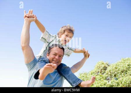 Father carrying son (8-9) sur les épaules Banque D'Images