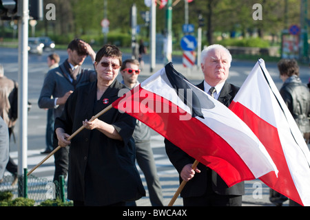 Un couple holding polish les drapeaux sur le jour de la cérémonie funéraire pour tous ceux qui sont morts dans la catastrophe de Smolensk, Poznan, Pologne Banque D'Images