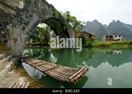 En radeau de bambou sur la rivière au pont Yulong, Guangxi, Chine Banque D'Images