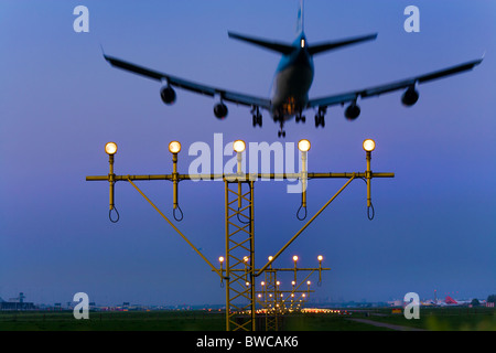 Avion avion KLM approchant, l'atterrissage sur la piste de Kaagbaan l'aéroport Schiphol d'Amsterdam au crépuscule. Banque D'Images