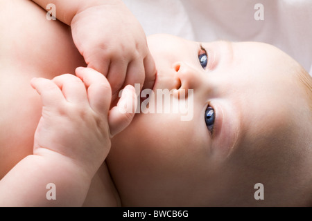 Close-up of innocent baby gardant ses doigts dans la bouche Banque D'Images