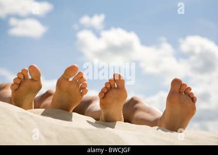 Image de la plante des deux personnes se trouvant sur la plage de sable Banque D'Images