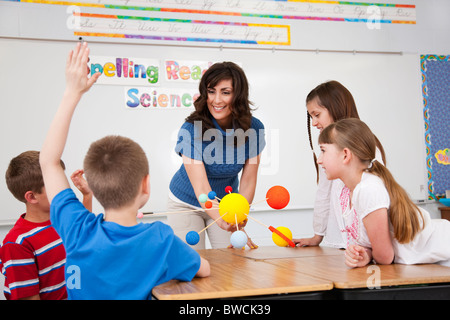 États-unis, Illinois, Metamora, écoliers (8-9, 10-11) et l'enseignante avec le modèle du système solaire à la classe de sciences Banque D'Images