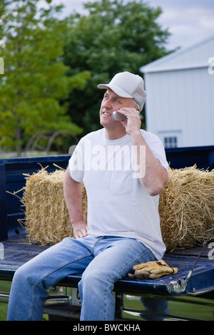 États-unis, Illinois, Metamora, agriculteur à l'aide de téléphone mobile sur chariot Banque D'Images