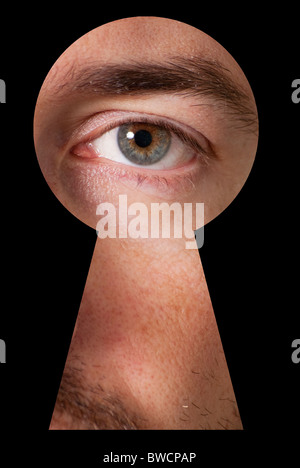 Les yeux masculins, regardant à travers un trou de serrure avec contour noir Banque D'Images