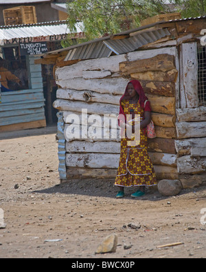 Indigènes colorés femme attend dans l'ombre de sa tour dans un petit village rural en Tanzanie. Banque D'Images