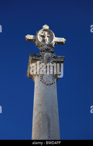 Un vieux pilier avec une sculpture de la crucifixion sur le dessus à Zurrieq ville à Malte. Banque D'Images