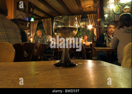 Photographie d'un verre de vin à moitié plein sur une table, pub intérieur, Mainz, Allemagne Banque D'Images