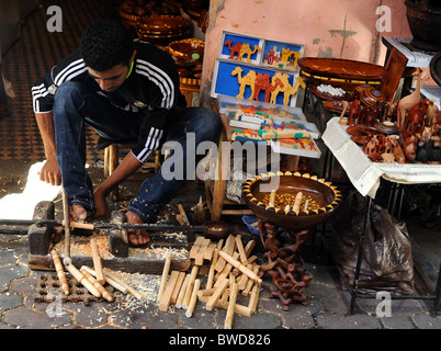 Un artisan sculpte les articles à partir de bois avec un tour à l'aide de ses pieds dans un souk à Marrakech. Banque D'Images