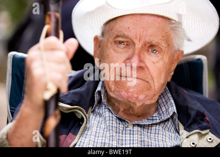 Un portrait d'un vieil homme grincheux assis sur une chaise Banque D'Images