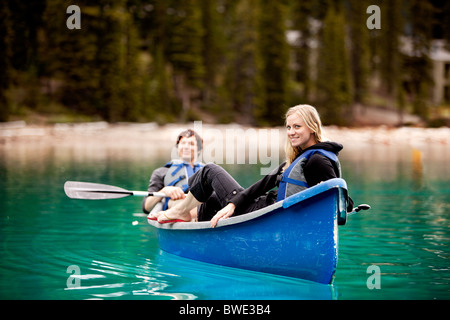 Un couple heureux de vous détendre dans un canoë sur un lac glaciaire Banque D'Images