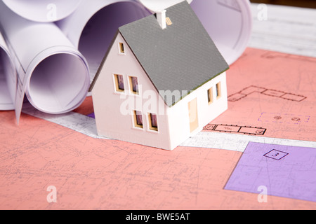 Close-up of toy house model with blueprints laminées près de par Banque D'Images