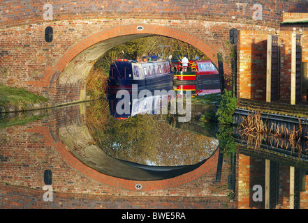 Un pont de bateaux et reflétée dans le Grand Union Canal à Blisworth Arm, le Northamptonshire, Angleterre Banque D'Images