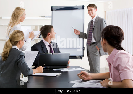 Image de smart business personnes regardant leur chef alors qu'il a expliquer quelque chose sur le tableau blanc au cours de séminaire Banque D'Images