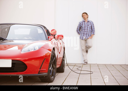 Jeune homme de remplir sa voiture électrique
