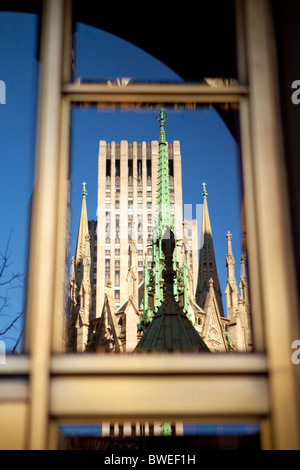 Statue du Christ de cuivre sur le dessus de la Cathédrale St Patrick, le Rockefeller Center en arrière-plan. Banque D'Images