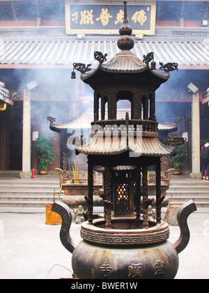 À l'intérieur d'un temple bouddhiste à Hangzhou en Chine, avec de la fumée provenant de la combustion des braises de l'encens Banque D'Images