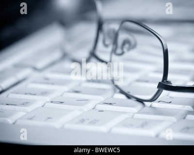 Verres sur le clavier de l'ordinateur ,libre,focus sélectif et, dans les tons bleus pour divers,bureau ou de recherche speedyfind Banque D'Images