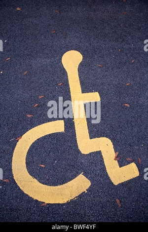 Mobilité fauteuil roulant personne symbole sur le bitume dans un blue badge de parking dans un parking Banque D'Images