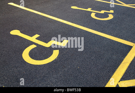 Mobilité fauteuil roulant personne symbole sur le bitume dans un blue badge de parking dans un parking Banque D'Images