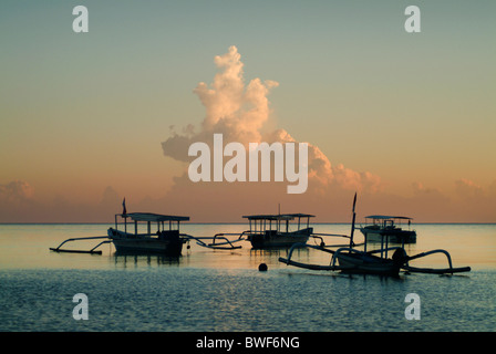 Dans la baie du village de pêcheurs de Pemuteran, Bali, les bateaux de pêche restent ancrées en attente de sortir dans la nuit pour la pêche. Banque D'Images