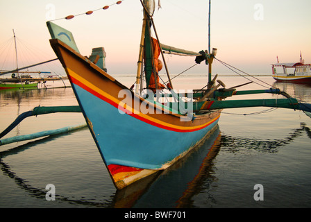 Un bateau de pêche balinaise, appelé un Jukung, est une pirogue pirogue peints dans des couleurs traditionnelles, équipé d'une voile. Banque D'Images