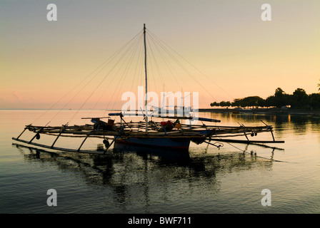Dans la baie du village de pêcheurs de Pemuteran, Bali, les bateaux de pêche restent ancrées en attente de sortir dans la nuit pour la pêche. Banque D'Images