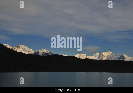 Sommets des Andes enneigées s'élevant au-dessus de la crête d'une colline sombre le long des rives du lac Argentino, près de l'Upsala Glacier, Patagonie Banque D'Images