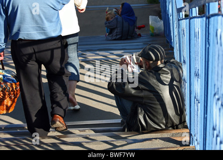 Un changeur de monnaie assise sur les marches d'une passerelle, Brest, Biélorussie Banque D'Images