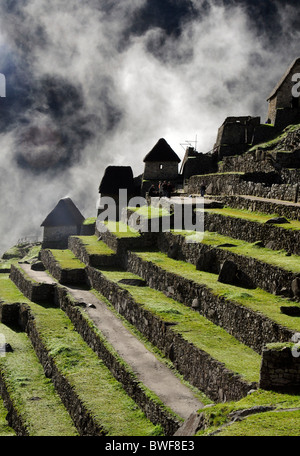 La brume et les nuages passant près de la terrasse de l'inca du Machu Picchu Tôt le matin. Banque D'Images