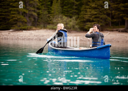 Un homme et une femme pagayer en canoë sur un lac Banque D'Images