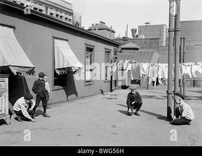 Vintage photo c1910 de jeunes garçons jouant aux billes sur le toit d'un immeuble "gratte-ciel" dans la ville de New York. Banque D'Images