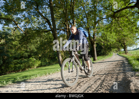 Vélo homme vers le bas une route de terre Banque D'Images