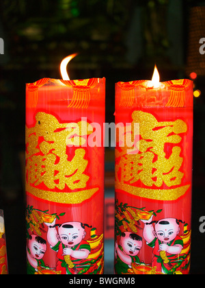 Décorée dans des couleurs vives, deux bougies chinoises dans un temple à Shanghai, où les proies sont dit Banque D'Images