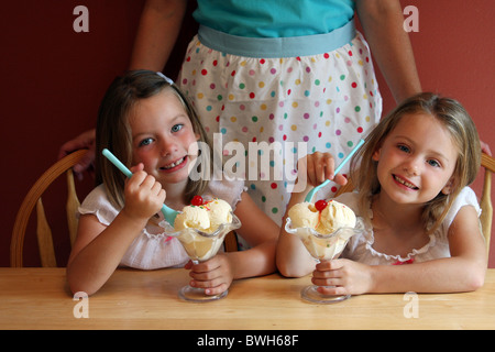 Une maman avec deux jeunes enfants eating ice cream sundae Banque D'Images