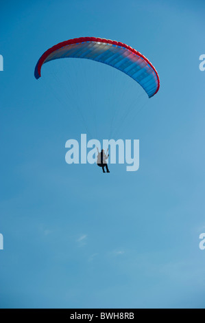 Parapentes viennent pour terres contre ciel bleu clair. Banque D'Images