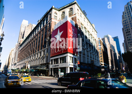 USA New York NYC Manhattan du grand magasin Macy's avec des voitures sur la 34e rue et les gens qui marchent dans la rue piétonne de Broadway. Banque D'Images