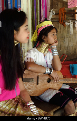 Deux réfugiés Karen Paduang s'asseoir à l'extérieur de leur maison à Ban Nai Soi, en Thaïlande. Banque D'Images