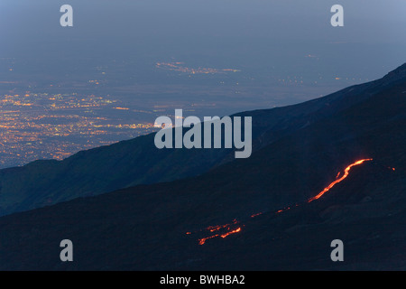 Flux de lave, des lumières de Catane dans la vallée, Parco dell'Etna National Park, côté nord du mont Etna, en Sicile, Italie Banque D'Images