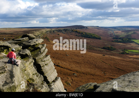 Female rock climber sur Stanage Edge dans le Peak District, Derbyshire, Angleterre Banque D'Images